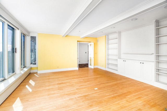 empty room featuring beamed ceiling, built in features, baseboards, and light wood finished floors