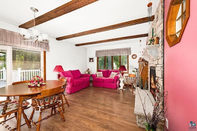 dining area featuring beamed ceiling, a notable chandelier, wood finished floors, and a fireplace