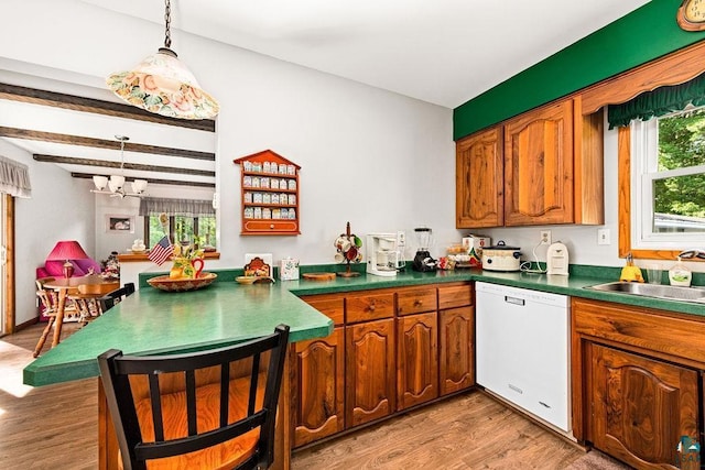 kitchen featuring dishwasher, light wood-style flooring, a notable chandelier, and a sink