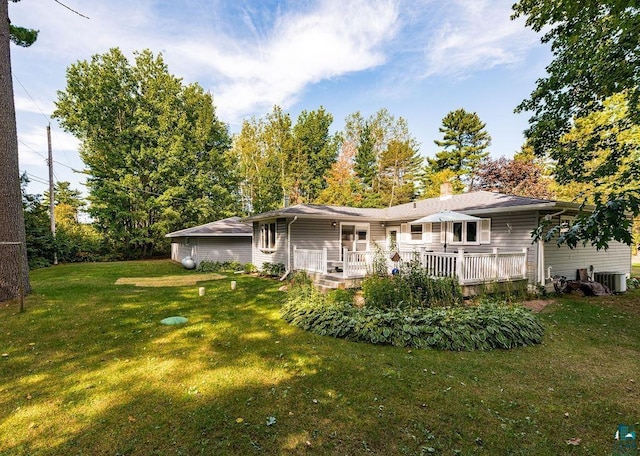 back of property featuring central air condition unit, a lawn, a chimney, and a deck