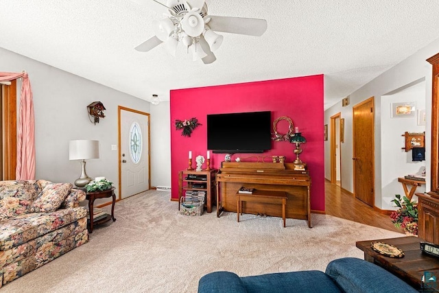 living room with ceiling fan, carpet floors, and a textured ceiling