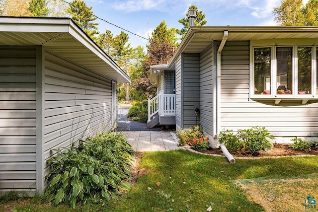 view of property exterior with a patio and a lawn