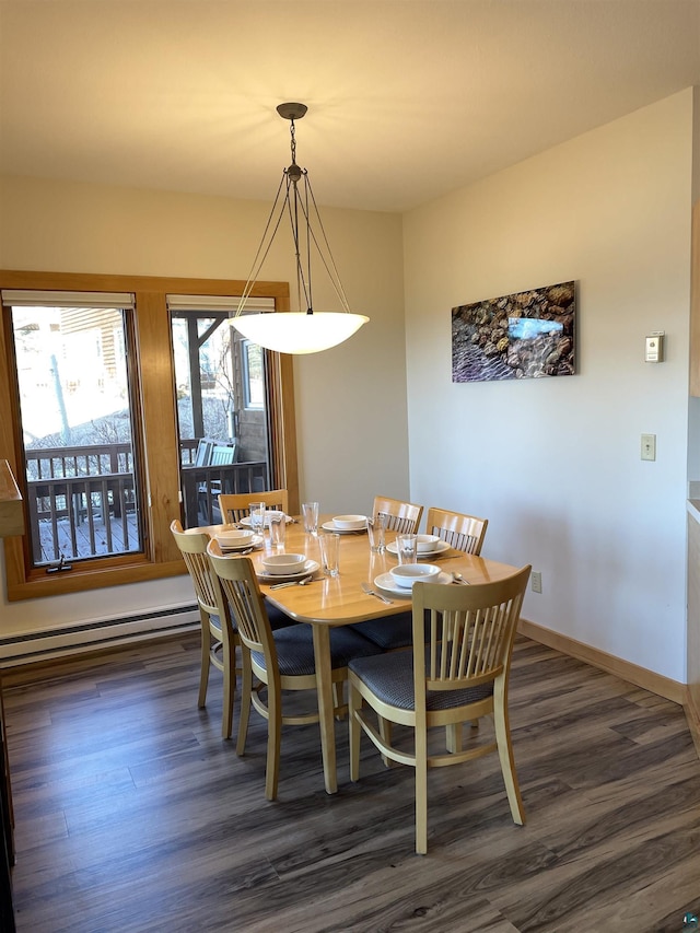 dining space with dark wood-style floors, baseboard heating, and baseboards