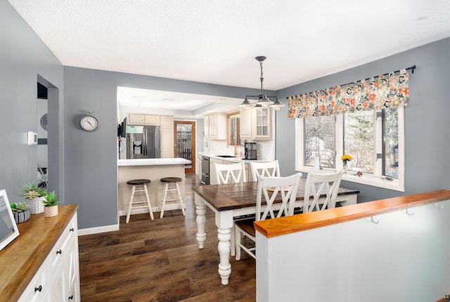 dining area with baseboards and dark wood-style flooring