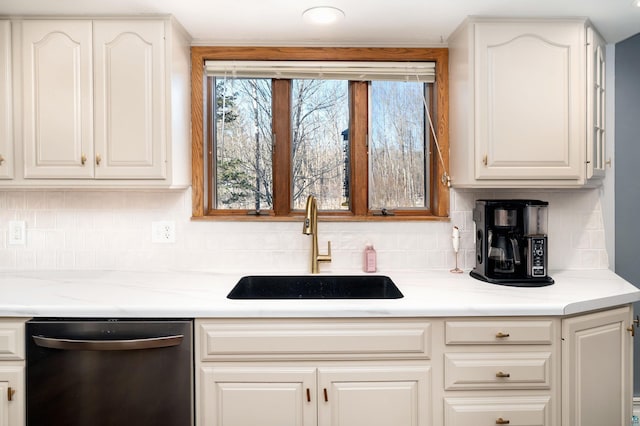 kitchen featuring dishwasher, white cabinetry, light countertops, and a sink