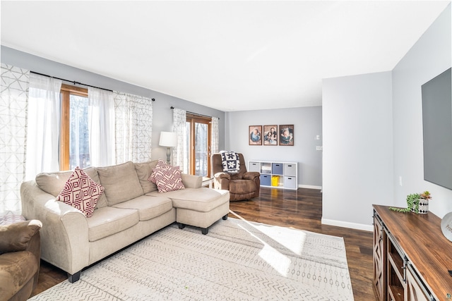 living room with dark wood-type flooring and baseboards