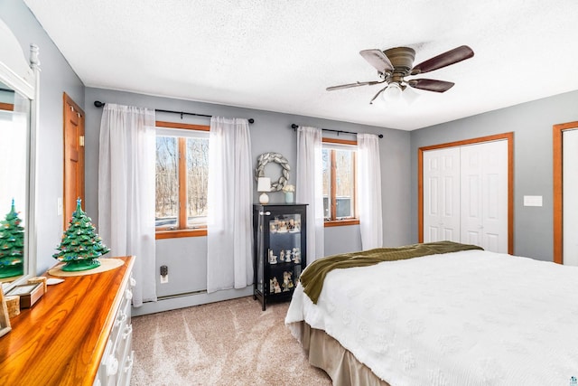 bedroom featuring a textured ceiling, a ceiling fan, and light carpet