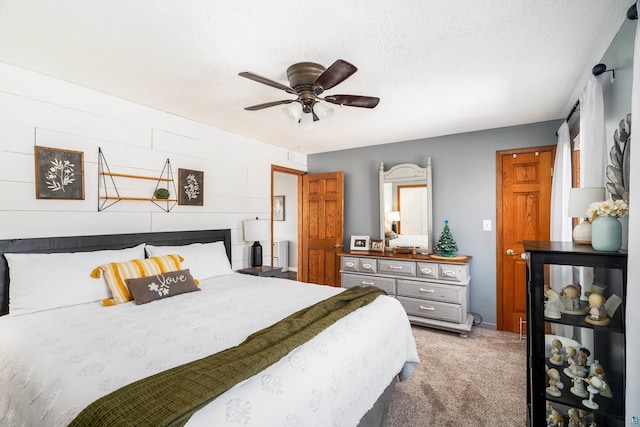 bedroom with a textured ceiling, ceiling fan, and light carpet