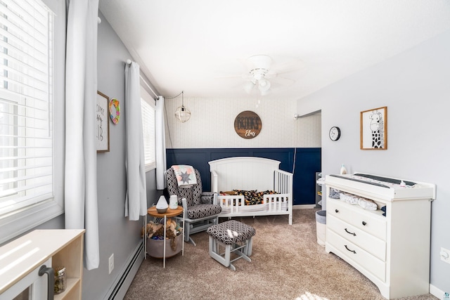 bedroom featuring a baseboard radiator, a nursery area, carpet, and wallpapered walls