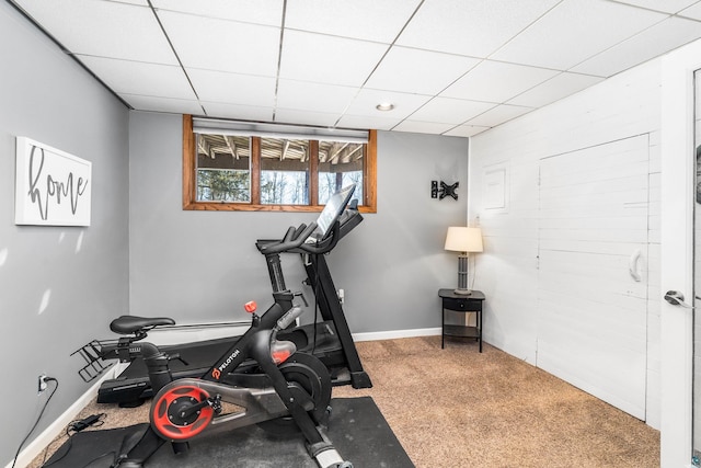 exercise room featuring a drop ceiling, carpet flooring, and baseboards