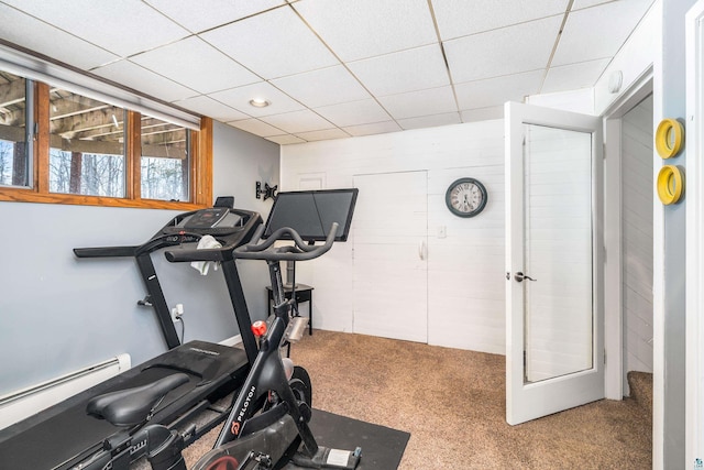 workout room featuring a baseboard heating unit, carpet flooring, and a drop ceiling