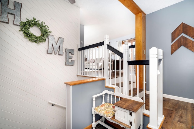 staircase with baseboards and wood finished floors