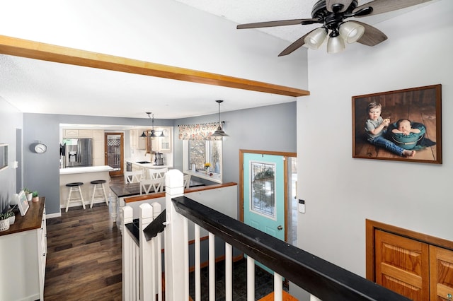 hall with baseboards, an upstairs landing, dark wood-type flooring, and a textured ceiling