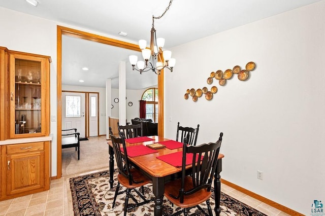 dining area featuring baseboards and a notable chandelier