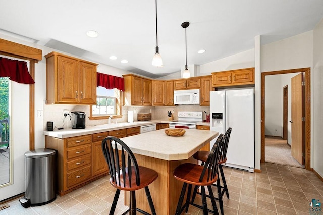 kitchen featuring white appliances, light countertops, backsplash, and a sink