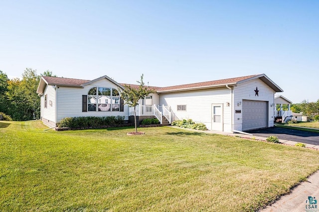 single story home with aphalt driveway, an attached garage, and a front yard