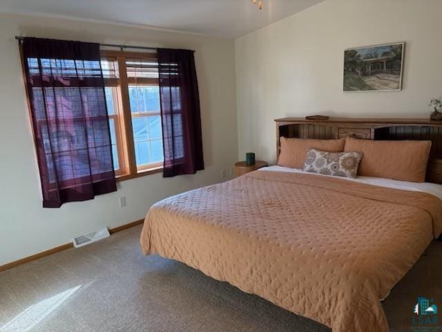 carpeted bedroom featuring visible vents and baseboards