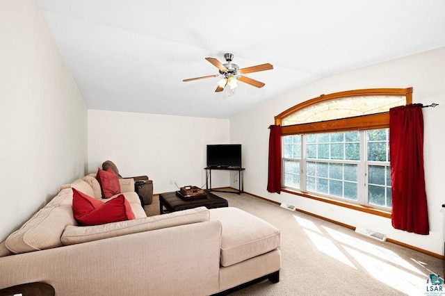 carpeted living room featuring vaulted ceiling, baseboards, visible vents, and ceiling fan