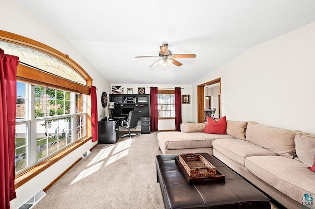 carpeted living area with plenty of natural light, visible vents, lofted ceiling, and ceiling fan