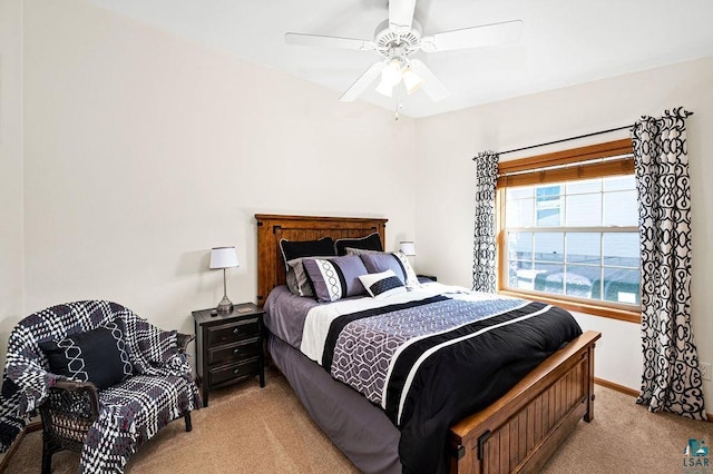 bedroom featuring baseboards, light carpet, and a ceiling fan