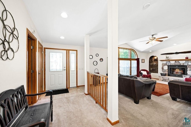 entryway featuring light colored carpet, a healthy amount of sunlight, a fireplace, and vaulted ceiling