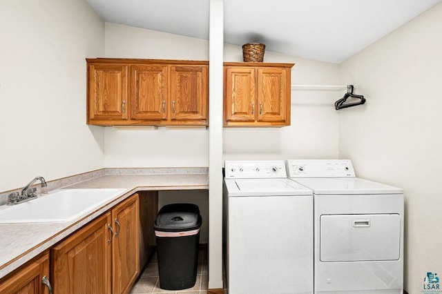 clothes washing area featuring separate washer and dryer, light tile patterned floors, cabinet space, and a sink