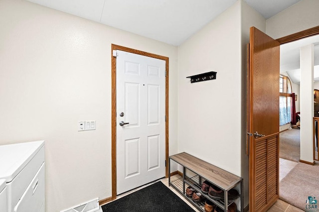 interior space with baseboards, washing machine and dryer, visible vents, and light carpet