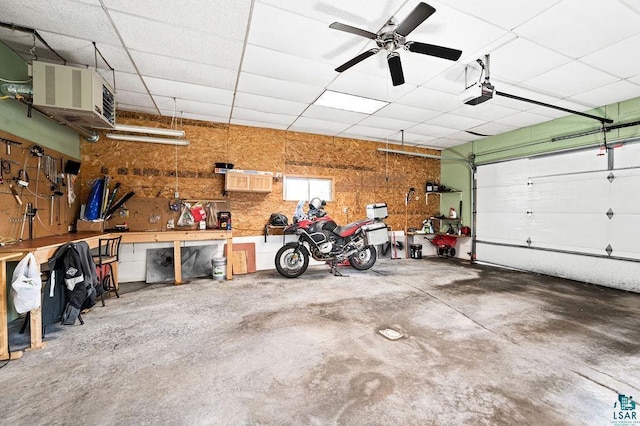 garage with a workshop area, a garage door opener, and ceiling fan