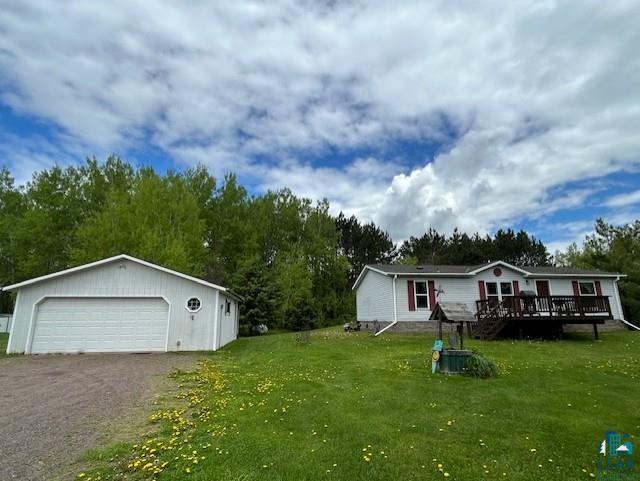 view of yard featuring a deck, an outdoor structure, and a garage