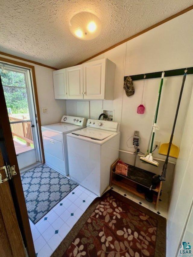 washroom featuring crown molding, cabinet space, separate washer and dryer, and a textured ceiling