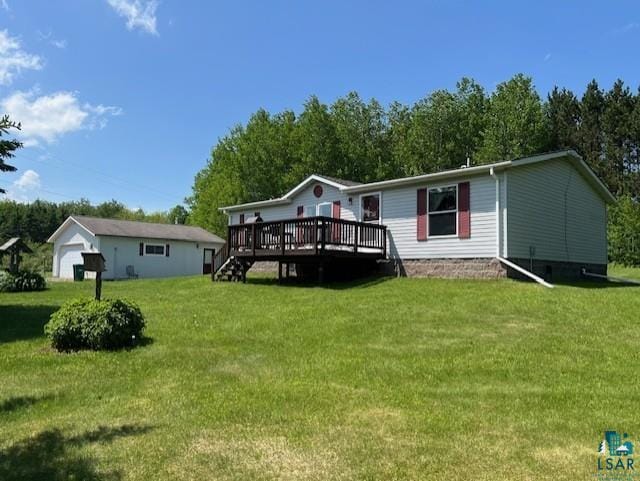 back of house with an outbuilding, a lawn, a wooden deck, and a detached garage