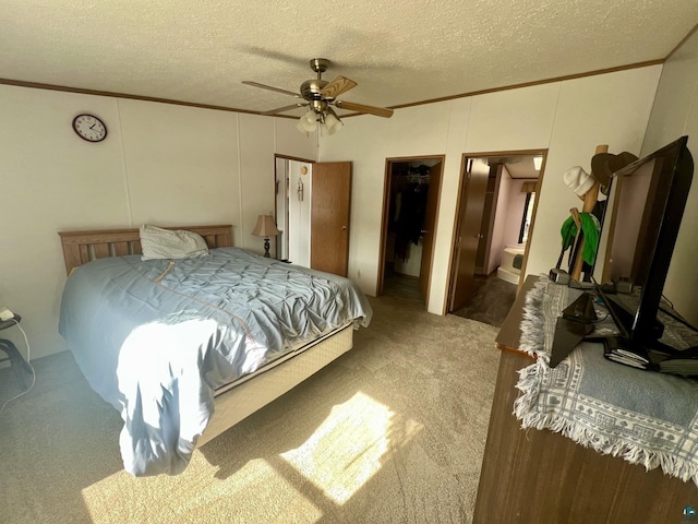 bedroom with a textured ceiling, a ceiling fan, carpet floors, and ornamental molding