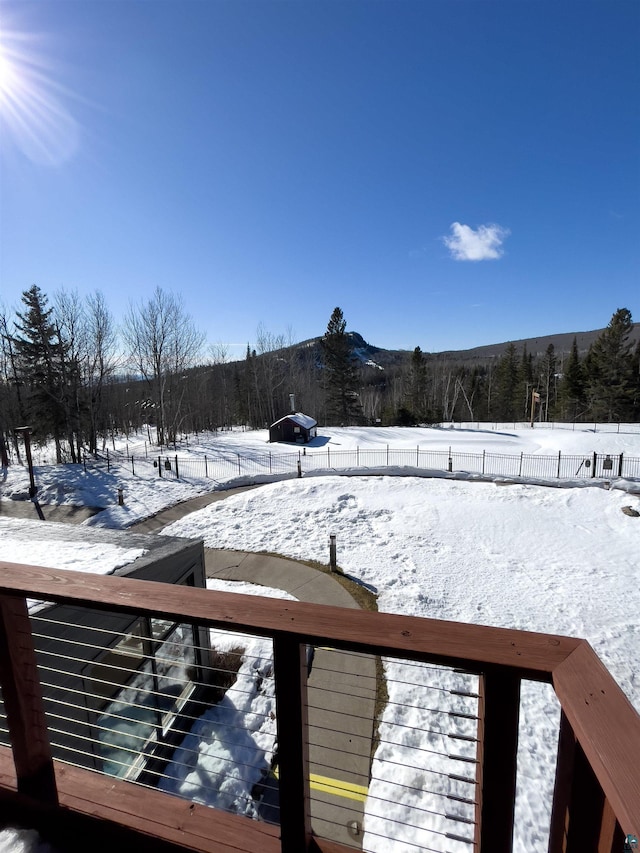 snowy yard featuring fence and a mountain view