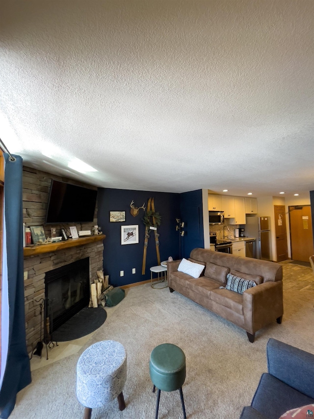 living area with a stone fireplace, a textured ceiling, recessed lighting, and light carpet