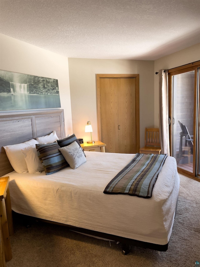 carpeted bedroom with a closet, a textured ceiling, and access to outside