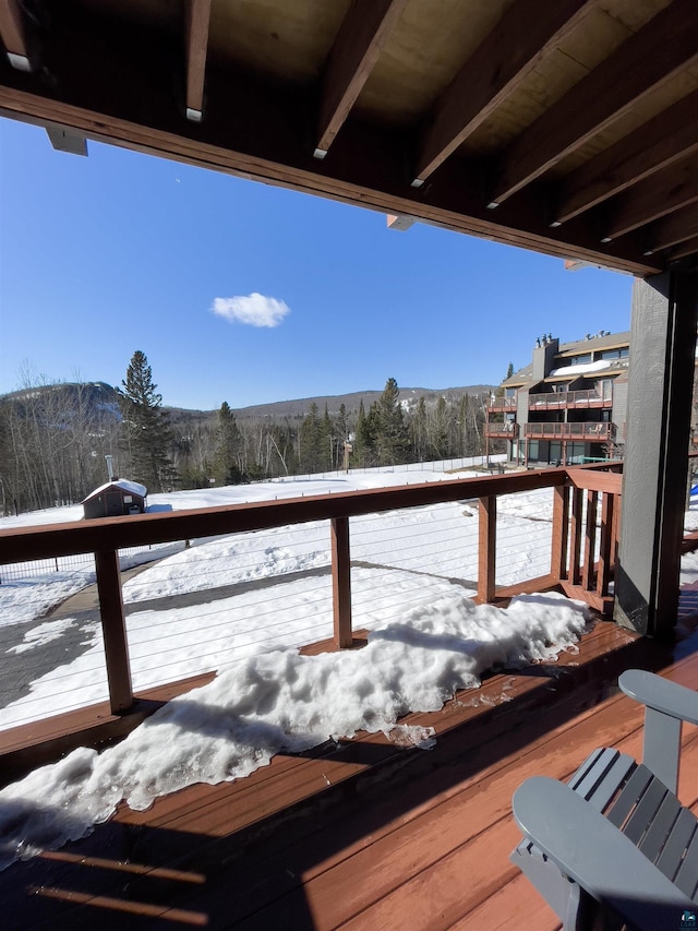 snow covered deck with a mountain view and grilling area