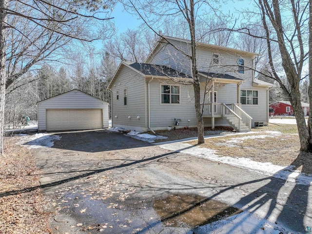 view of front of home with a garage and an outbuilding