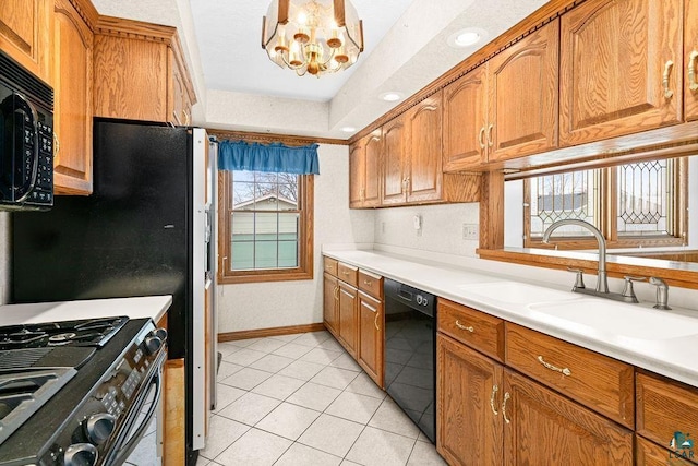 kitchen with brown cabinetry, black appliances, and a sink