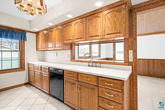 kitchen featuring light tile patterned floors, brown cabinetry, light countertops, wood walls, and dishwasher