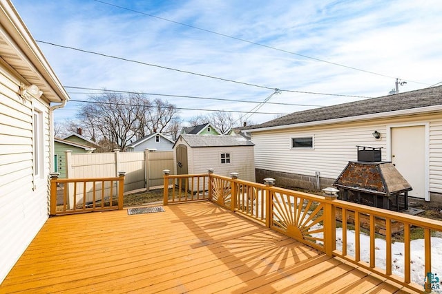 deck featuring a storage shed, an outbuilding, and fence