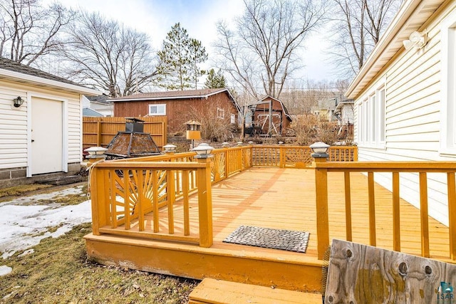 wooden deck featuring an outbuilding and fence