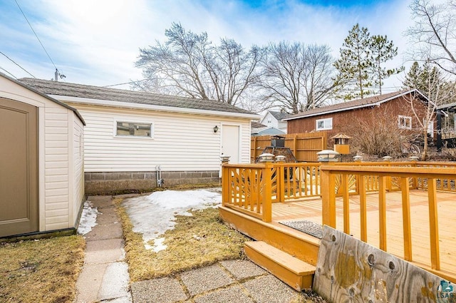 wooden terrace with an outdoor structure and fence