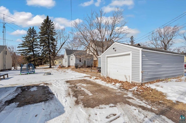 snow covered garage with a trampoline and a garage