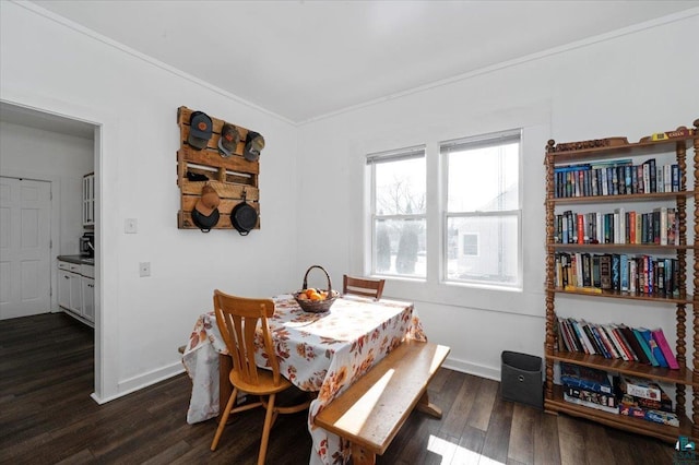 dining space featuring baseboards, dark wood-type flooring, and crown molding