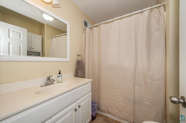 bathroom featuring visible vents, a textured ceiling, and vanity