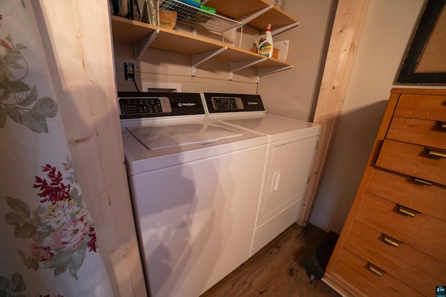 clothes washing area featuring laundry area, dark wood-style flooring, and washing machine and clothes dryer