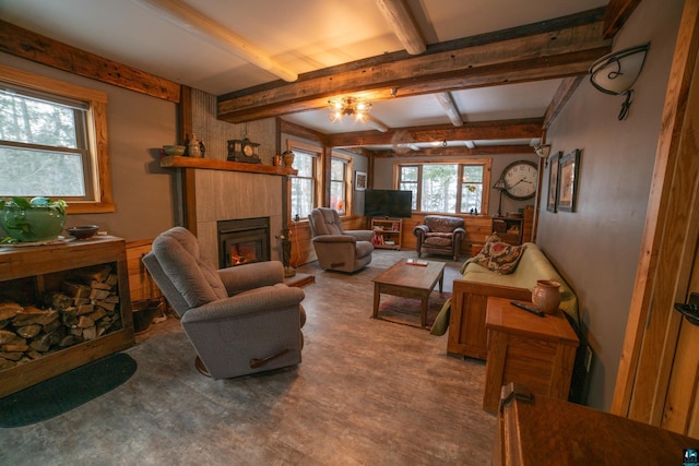 living room featuring beam ceiling and a tiled fireplace