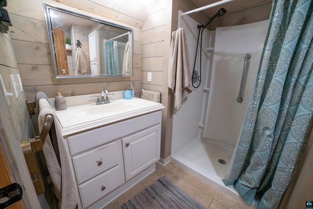 bathroom with vanity, tile patterned flooring, a stall shower, and wood walls