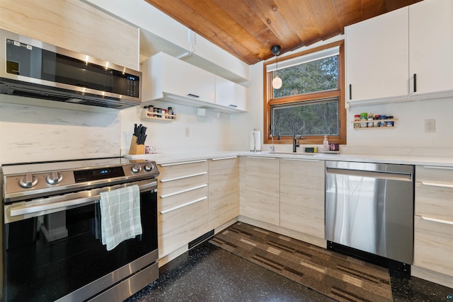 kitchen featuring modern cabinets, a sink, stainless steel appliances, wooden ceiling, and light countertops