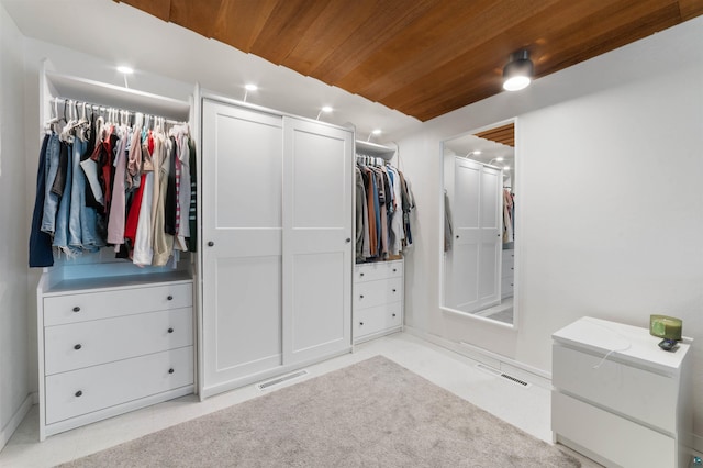 walk in closet with visible vents and light colored carpet